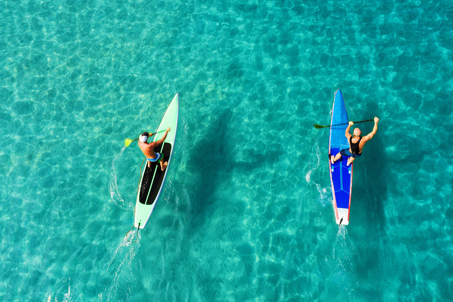 Paddleboarding sulla tranquilla superficie del mare