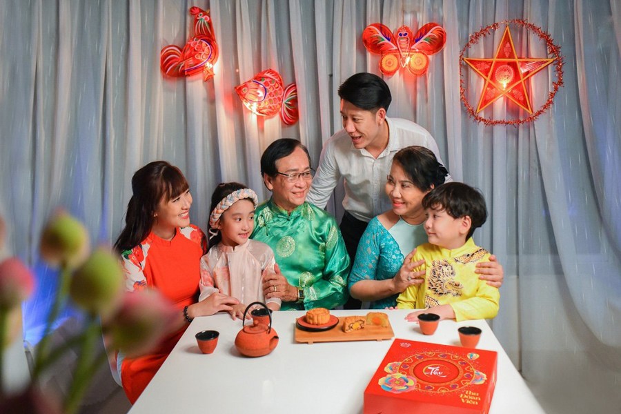 La famiglia riunita per gustare mooncake e tè sotto la luna