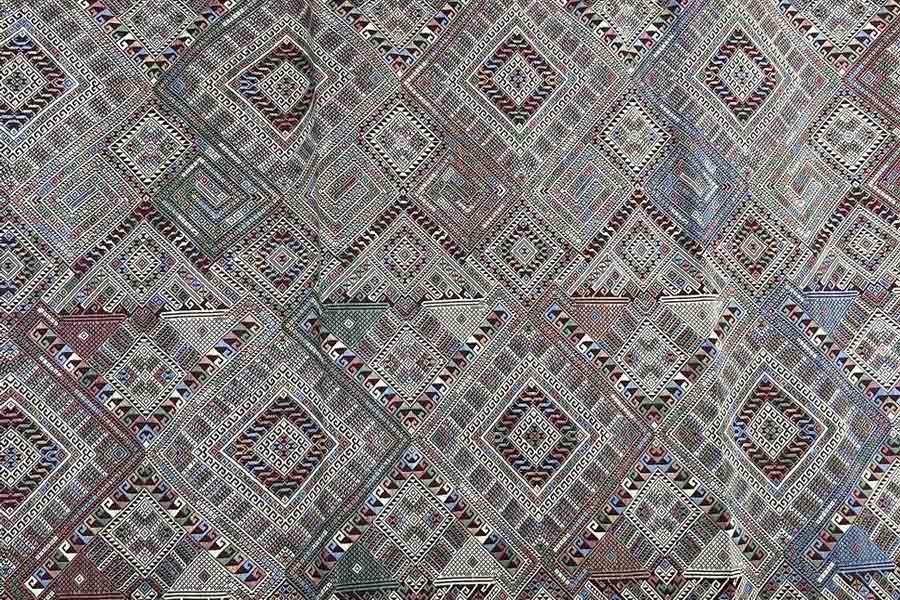 Motivo del naga intrecciato sulla seta ikat, simbolo di spiritualità e protezione nella cultura laotiana.