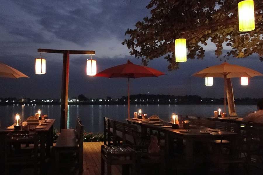 Ammirare il tramonto al fiume Mekong con una tazza di caffè