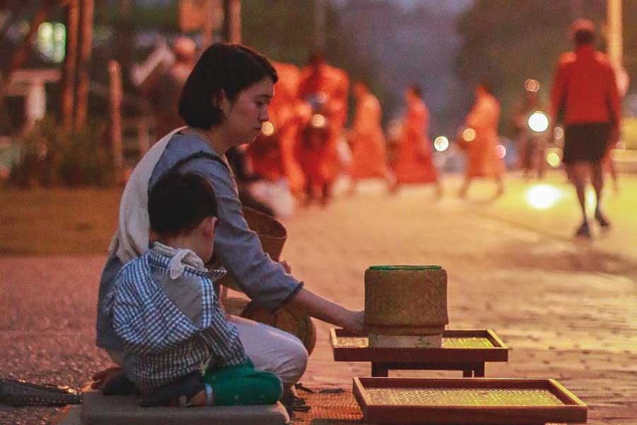 Il bambino partecipa alla cerimonia Tak Bak con la sua madre